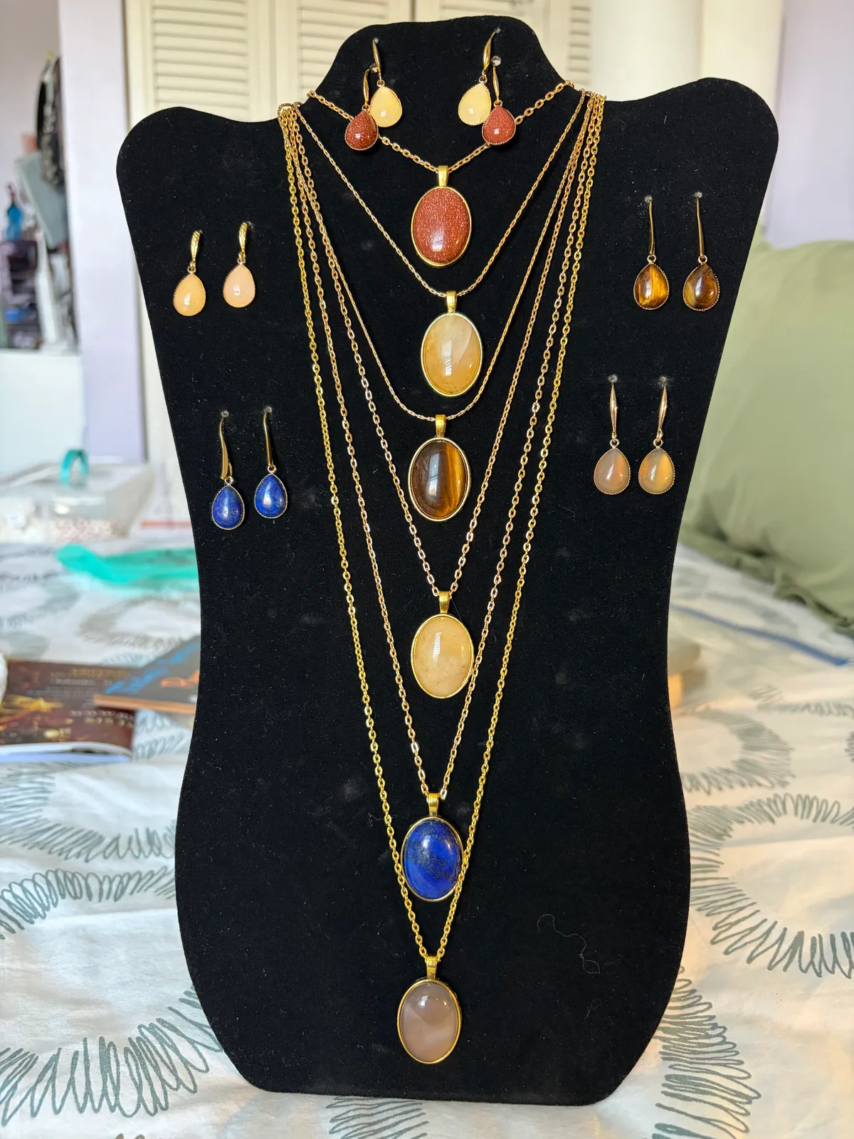 Display of Patty's gold stone pendant necklaces and earrings